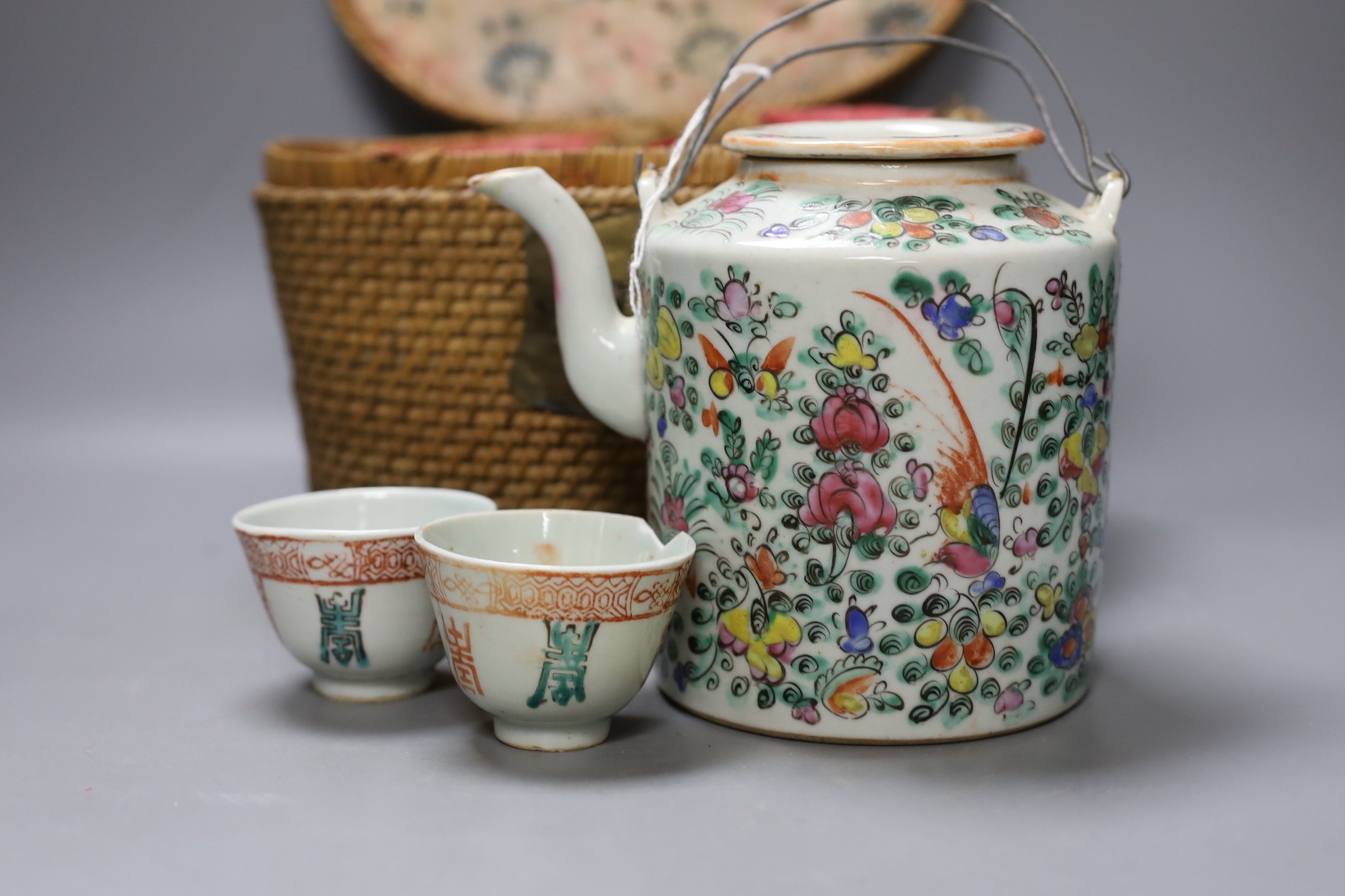 A Chinese teapot and two tea bowls in carrying basket, two Chinese blue figures, and a Chinese enamelled porcelain brush washer, 9.5cm diameter (5)